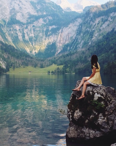 女人坐在石头湖附近

